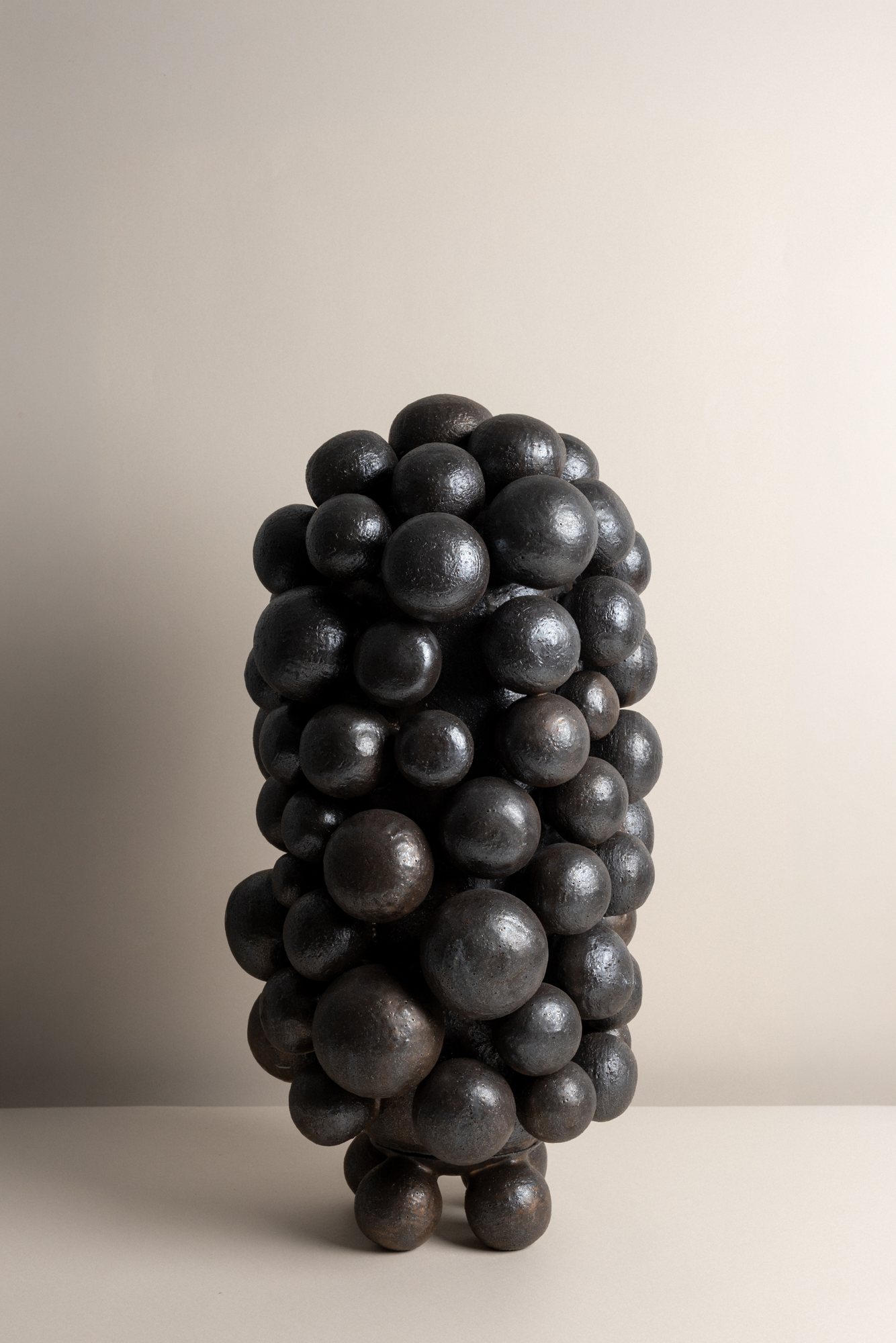A tall vessel built from clustered black spheres