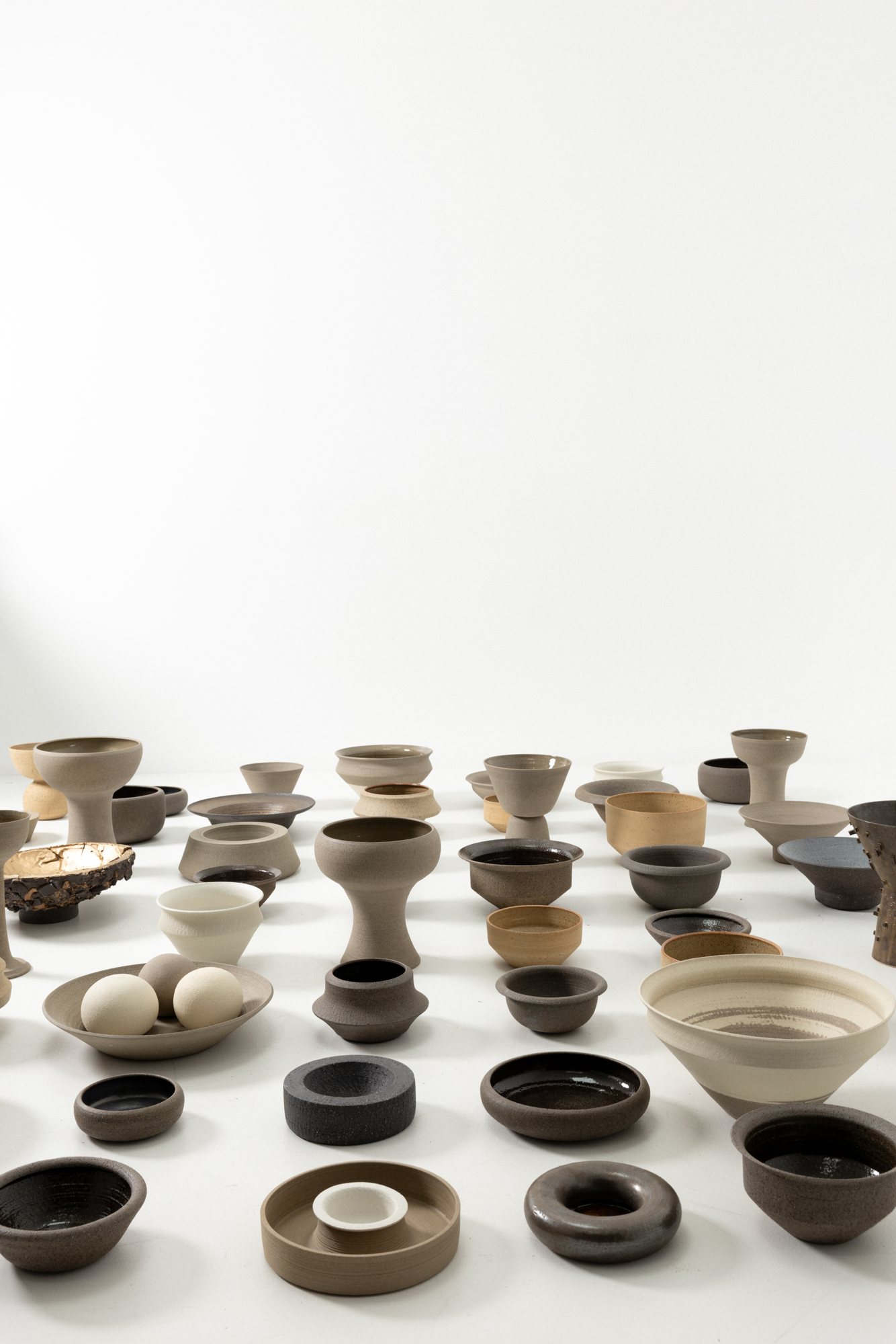 Bowls, vessels and lamps gathered on the studio floor