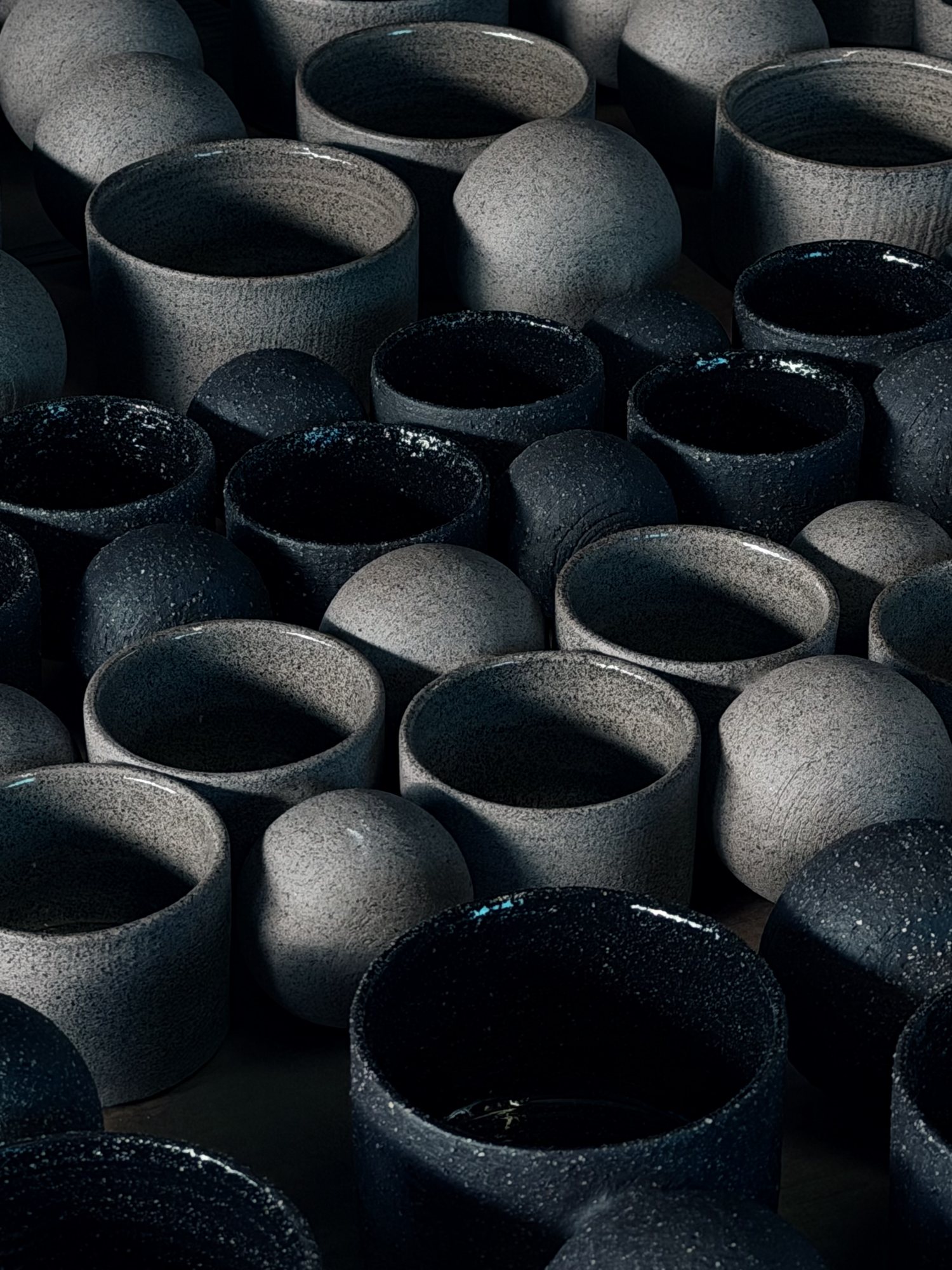 A run of black cups, fresh from the kiln